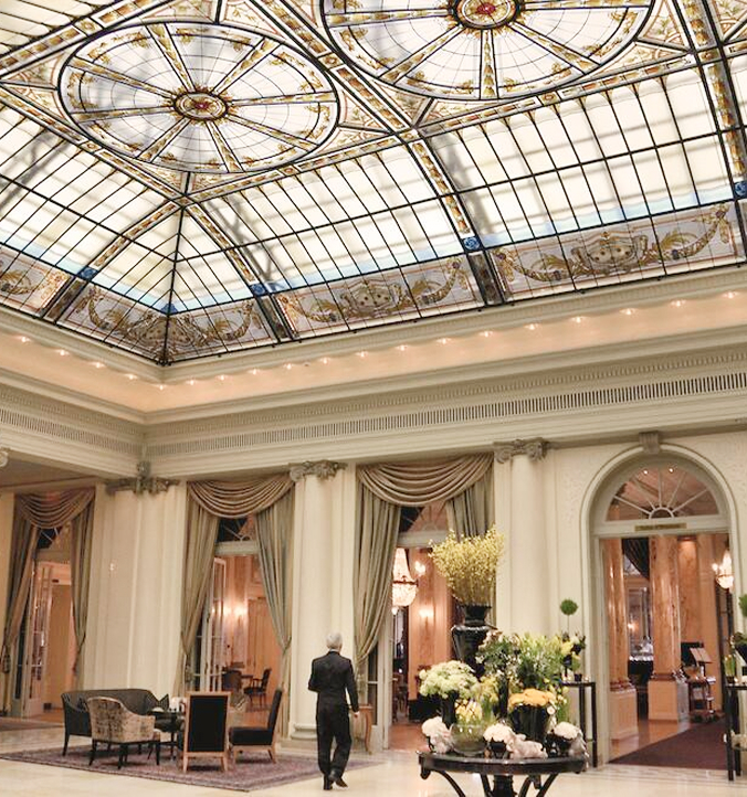 Elegant hotel lobby beneath a grand glass-domed ceiling