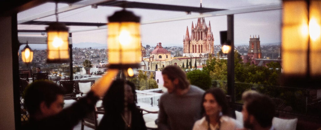 Couple enjoying an evening view of a city from an outdoor terrace