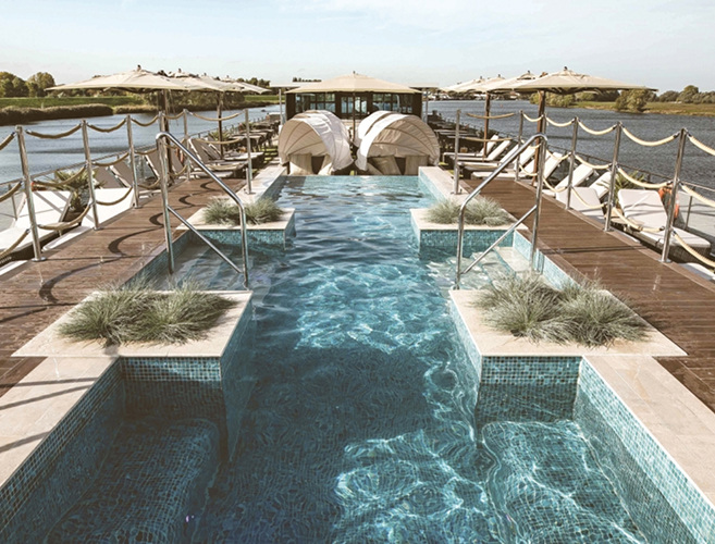 Infinity pool overlooking a luxury marina with yachts docked in the harbor