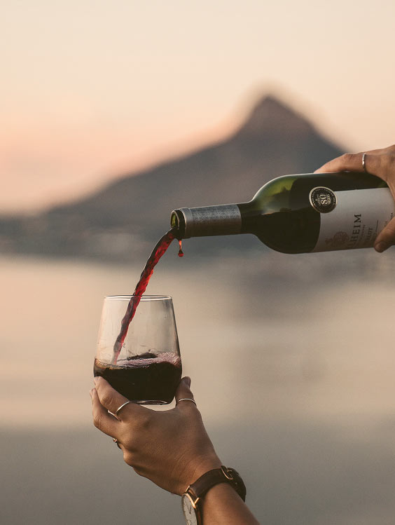 Red wine poured into a glass at sunset
