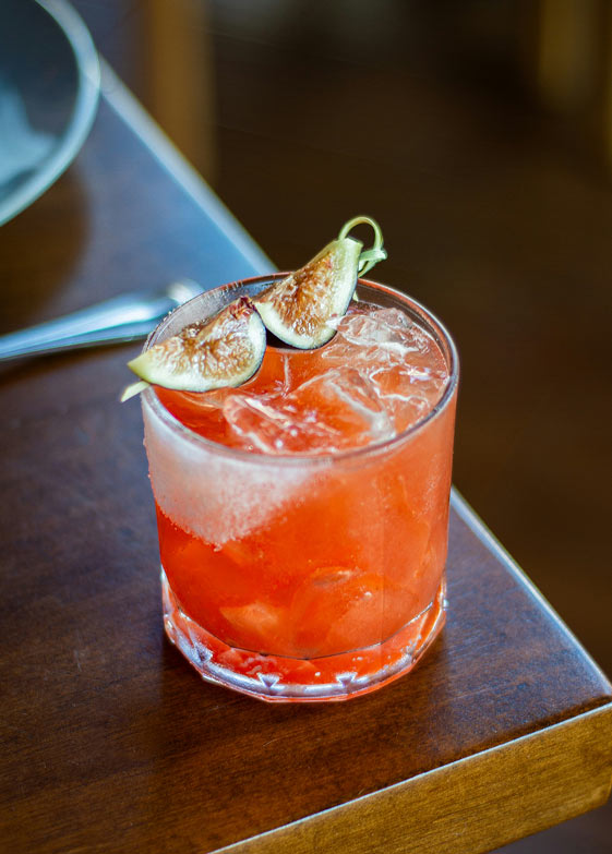 Red cocktail garnished with lime
